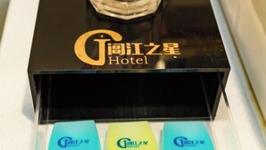 A hotel room with a black minibar and a glass of water. - Anmen Lijiang Inn (Qimen)