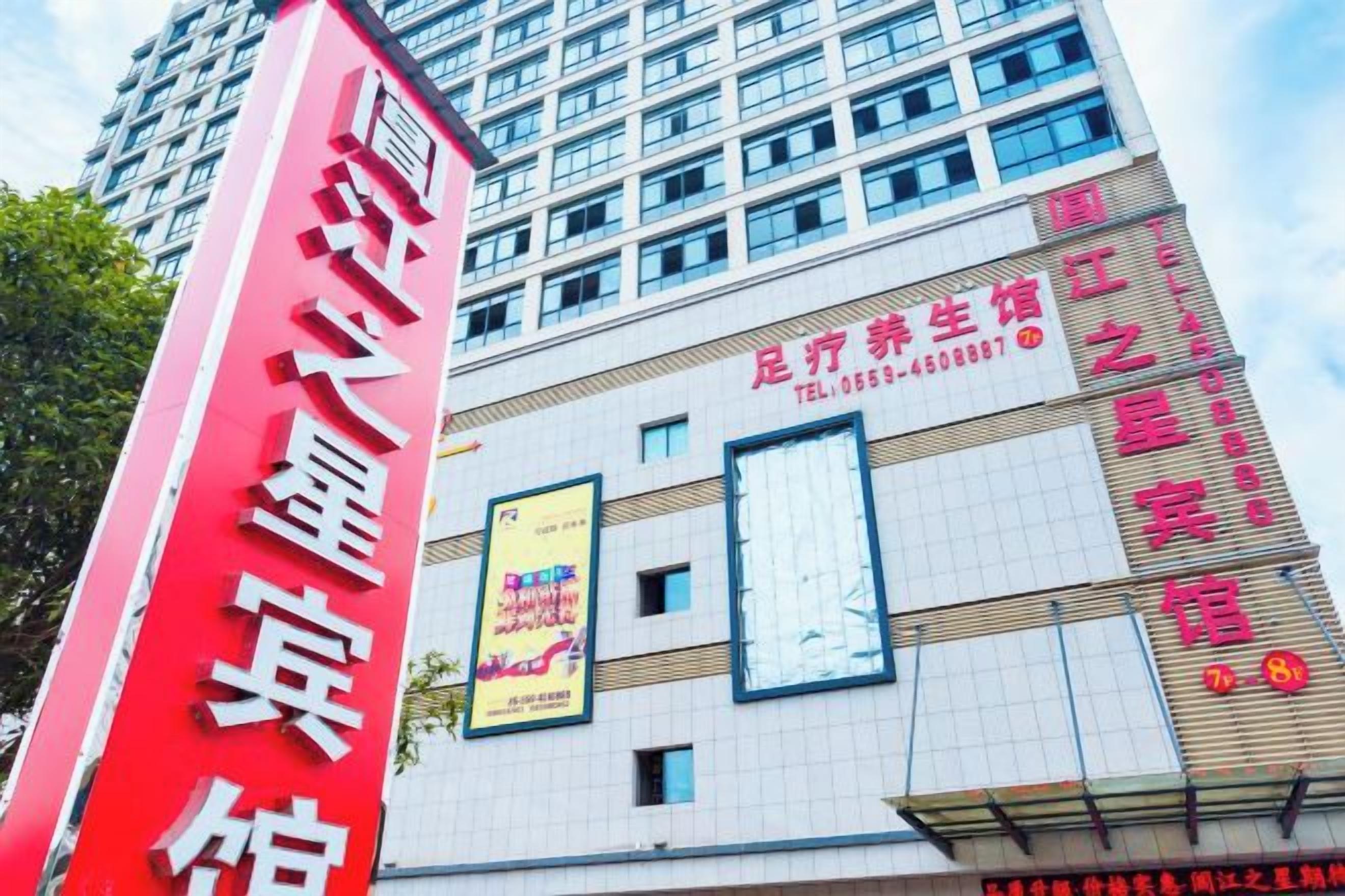 A tall building with a prominent red sign on the left.