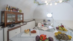 Une cuisine dotée d’un meuble en bois, d’un plan de travail en marbre et d’une variété de fruits et de légumes.