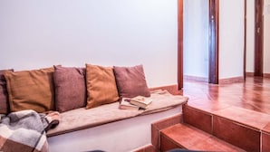 A seating area with a sofa and a bench, a book, and a door leading to another room. - Casa Centrale in central Sorrento (Sorrento)