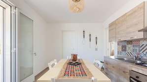 Una cocina moderna con una mesa de comedor, sillas y un mantel decorado.
