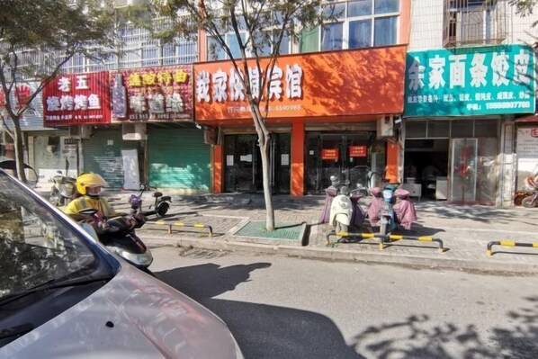 A street view with a building that has a sign for a restaurant and a shop. - Funan My Home Express Hotel (Funan)