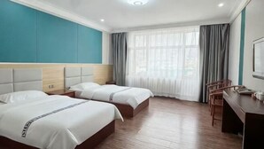 A hotel room with two beds, a desk, and a chair. - Fuyuan Xinyuan Hotel (Fuyuan)