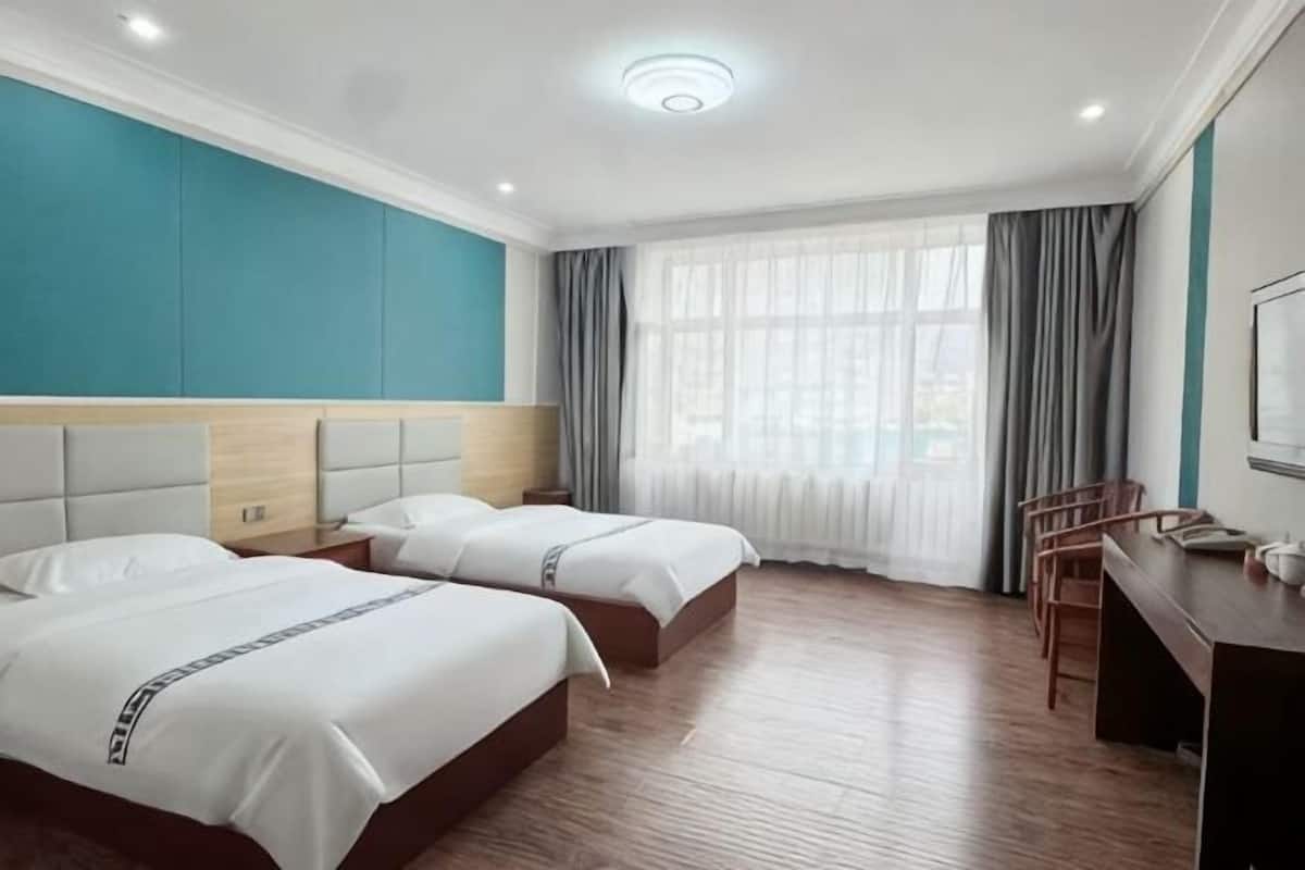 Una habitación de hotel con dos camas, un escritorio y una silla.