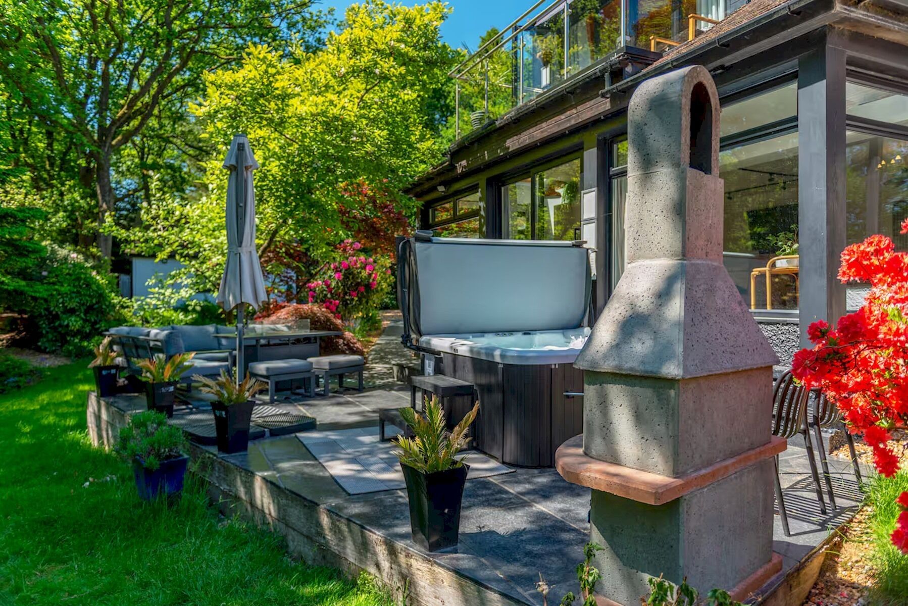A patio with outdoor furniture, a hot tub, and a stone oven.