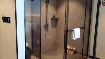 A glass-enclosed shower area with a towel rack and a small shelf.