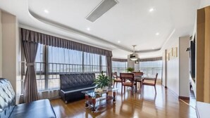 Una sala moderna con un sofá, una mesa de comedor, sillas y una mesa de centro.