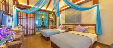 Habitación de hotel con dos camas, suelo de madera, televisión y techo decorativo.