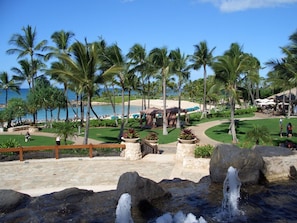 A resort with a pool, palm trees, and a waterfall. - 𝐅𝐢𝐧𝐝𝐢𝐧𝐠 𝐌𝐞𝐢𝐥𝐢’𝐬 Beachfront Fun at KoOlina Club Resort+Amenities.2BR (Kapolei)