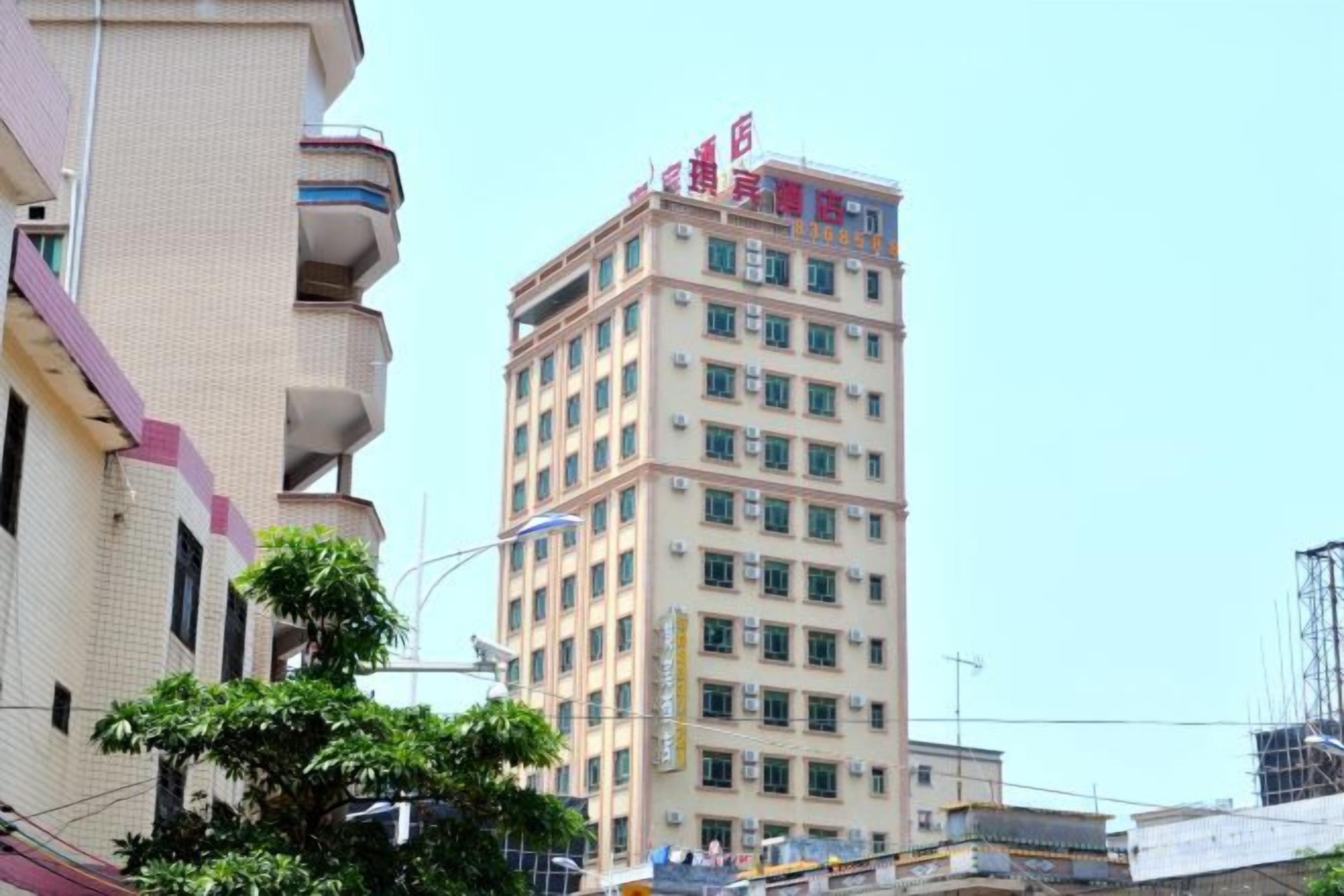 A multi-story building with a flat facade, balconies, and a clear sky.