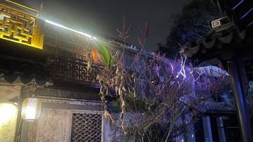 Un edificio tradicional con un acceso decorativo y un camino iluminado.