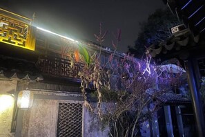 A traditional building with a decorative entrance and a lit pathway. - Pushe Guiyin Inn (Kunshan)