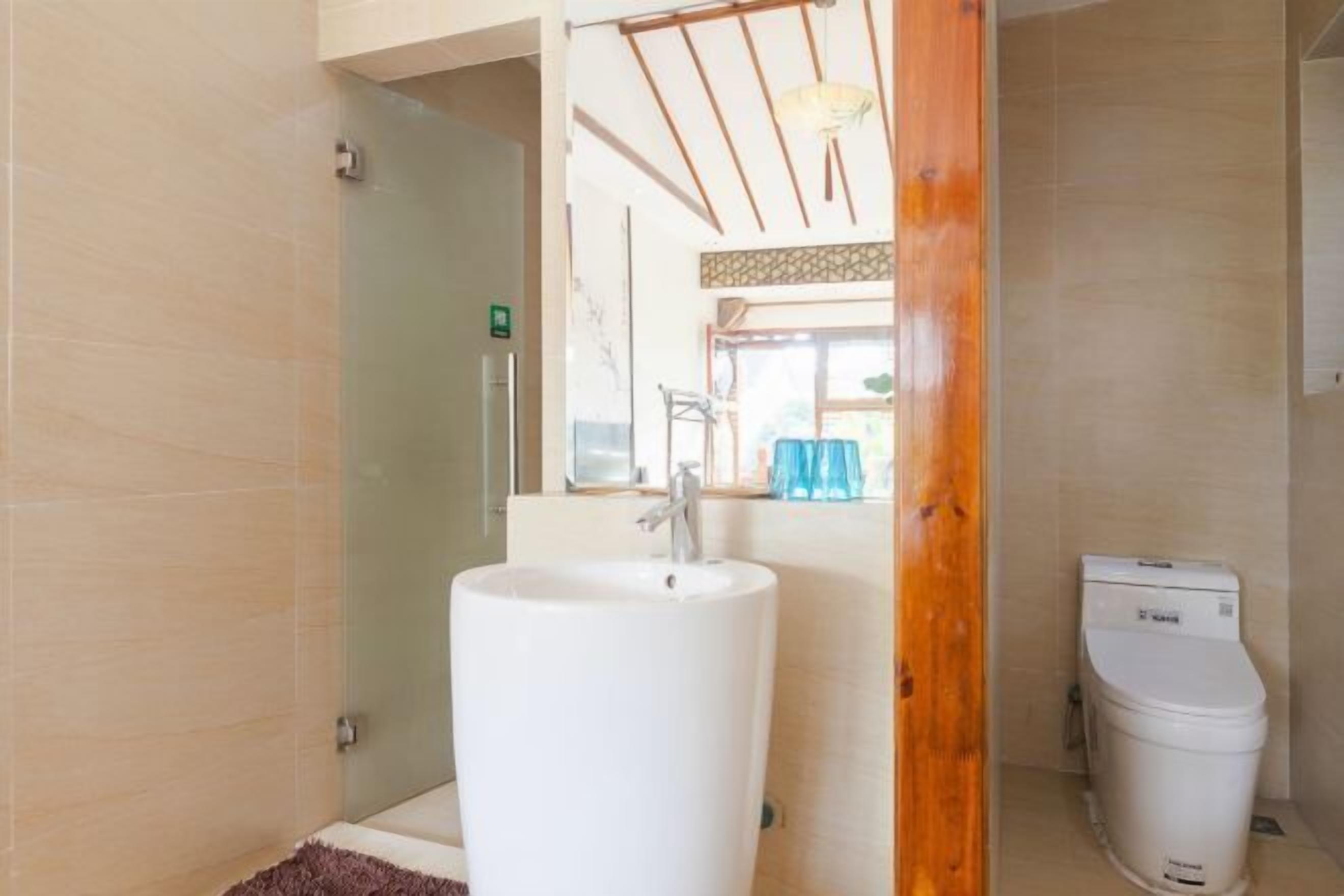 A bathroom with a white sink, a toilet, and a glass shower enclosure.
