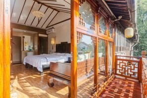 A traditional room with a bed, wooden flooring, and a balcony with a railing. - Pushe Guiyin Inn (Kunshan)
