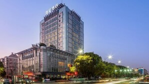 A modern hotel with a prominent glass facade and a rooftop sign. - PULUN HoTEL (Cixi Wuyue Plaza) (Cixi)