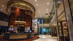 A lobby with a central circular reception area, a staircase, and a glass storefront. - PULUN HoTEL (Cixi Wuyue Plaza) (Cixi)