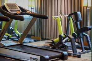 A gym with exercise equipment including a treadmill and weight machines. - PULUN HoTEL (Cixi Wuyue Plaza) (Cixi)