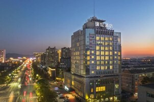 Un hotel moderno de gran altura, con varios pisos, amplias ventanas y un letrero llamativo en la parte superior.