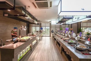 Un buffet avec plusieurs présentoirs de nourriture et un long comptoir.