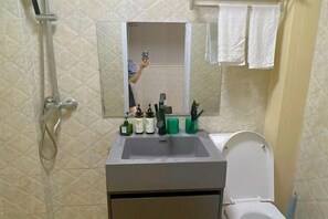 Ein Badezimmer mit Waschbecken, Spiegel und Toilette.