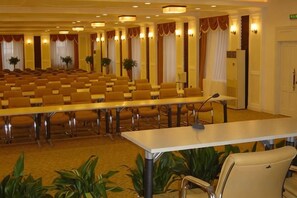 A conference room with rows of chairs, a long table, and a microphone. - Qingdao Tianheng Island Homestay (Qingdao)