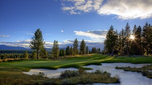 A golf course with sand bunkers, trees, and a clear sky. - The Cottages at Old Greenwood (Truckee)