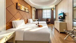 Ein Hotelzimmer mit Bett, Schreibtisch, Fernseher und Essecke.
