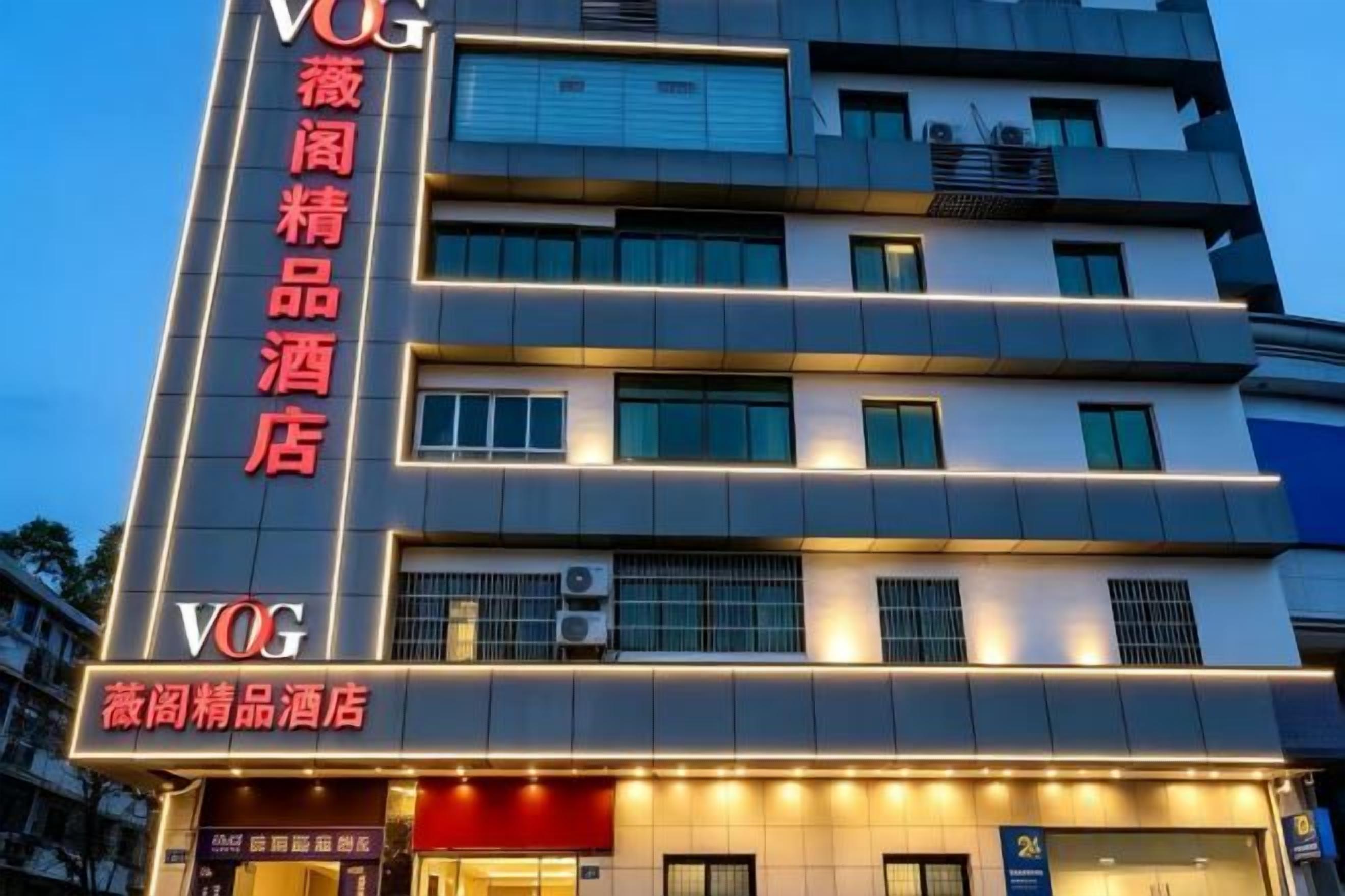 Monikerroksinen hotellirakennus, jossa on kyltit, jotka osoittavat sen olevan VOG-hotelliketjun hotelli.