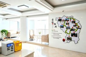 A modern hotel lobby with a wall map, a reception desk, and seating area. - weige Boutique Hotel (Shaoxing)