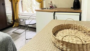 A compact kitchen with a microwave, a sink, and a small table. - Studio Sleeps 2 With Internet Access (London)