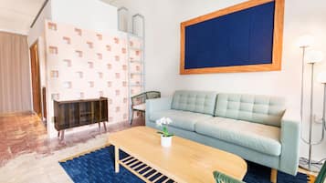 Habitación cuádruple junior, vista a la ciudad | Área de sala de estar | Smart TV