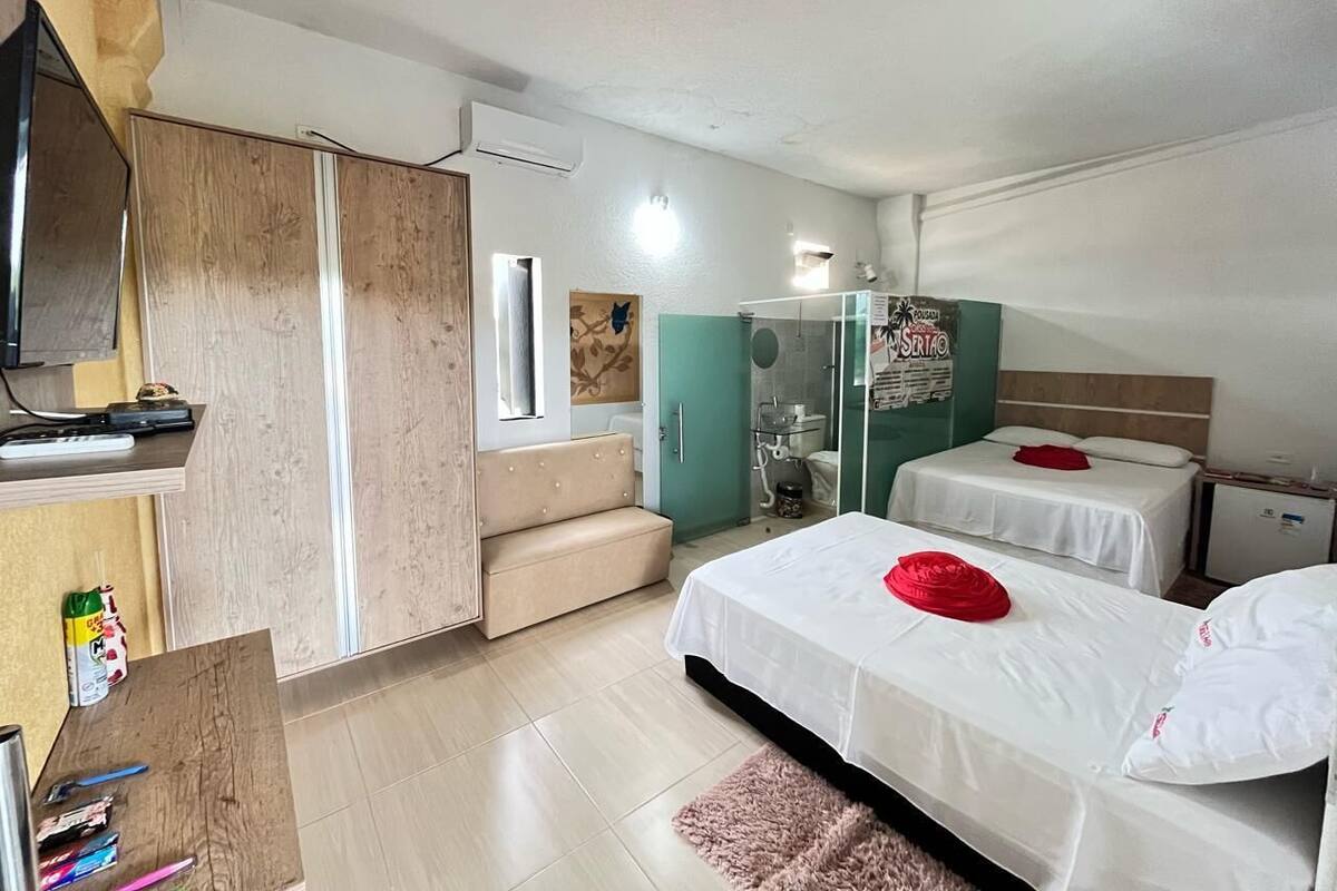 Ein Hotelzimmer mit Bett, einer Couch, einem Schreibtisch und einem Fernseher.