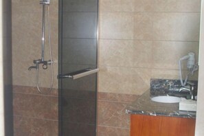 A bathroom with a glass-enclosed shower, a sink with a marble countertop, and a towel rack. - Taishun Bridge Xinge Hotel (Taishun)