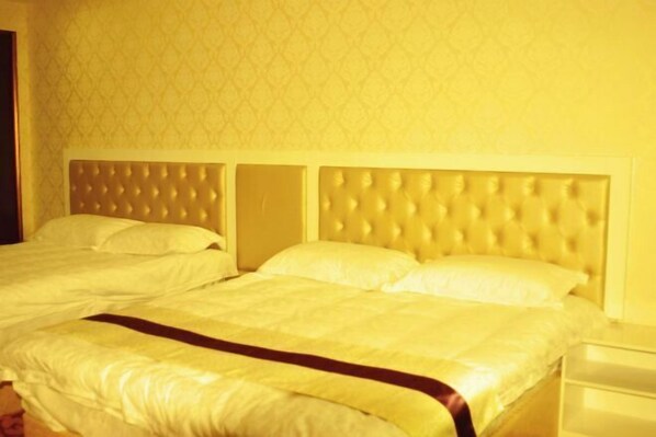 A hotel room with a large bed, a headboard, and a nightstand. - Taishun Bridge Xinge Hotel (Taishun)