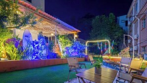 An outdoor patio area with a pool, seating, and decorative lighting. - Shenzhen Xinghai Xiaoye Inn (Shenzhen)