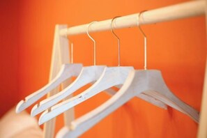 A white hanger rack against an orange background. - Shenzhen Xinghai Xiaoye Inn (Shenzhen)