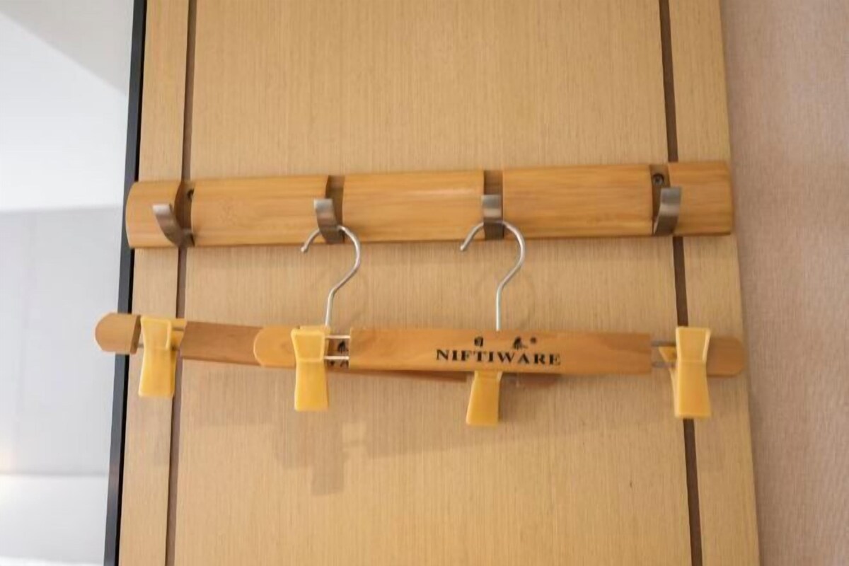 A wooden wall with two wooden racks, each holding yellow clips.