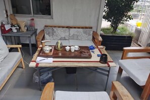 A dining area with a table set for tea, surrounded by wooden chairs and a sofa. - Hengsheng Hotel (Fuzhou Railway Station North Square) (Fuzhou)