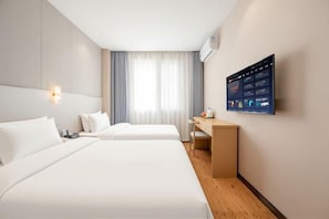 A hotel room with two beds, a desk, and a wall-mounted TV displaying a menu. - Hengsheng Hotel (Fuzhou Railway Station North Square) (Fuzhou)