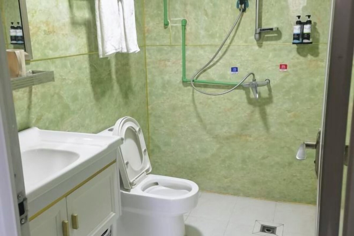 A bathroom with a toilet, sink, and shower.