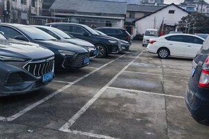 A parking lot with multiple cars parked in rows.
