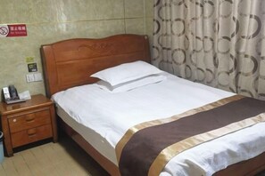 A neatly made bed with a wooden headboard, a bedside table with a lamp, and a curtain with a circular pattern. - hlkz (Xiuning)
