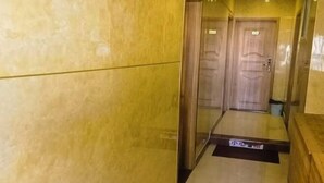 Um corredor com paredes de mármore e portas de madeira.