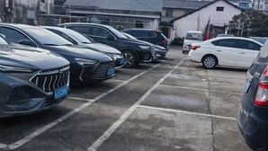 Um estacionamento com vários carros estacionados em fileiras.