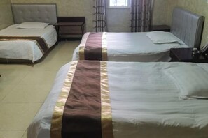 A hotel room with two beds, each with a headboard and a bedside table. - hlkz (Xiuning)