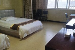 A hotel room with a bed, a desk, and chairs. - hlkz (Xiuning)