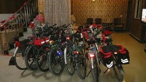 A room with a staircase, a patterned wall, and a row of bicycles.