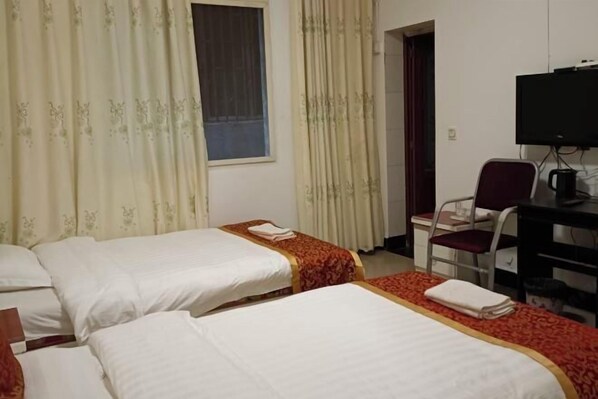A hotel room with two beds, a desk with a chair, a television, and a window with curtains. - yaan jinsanjiao hotel (Ya'an)