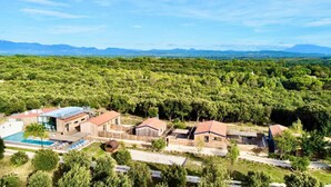 A modern resort with multiple buildings, a swimming pool, and a lush forest backdrop. - Comfortable 3-Bedroom Vacation Rental: NUIKI Lodges (Montségur-sur-Lauzon)