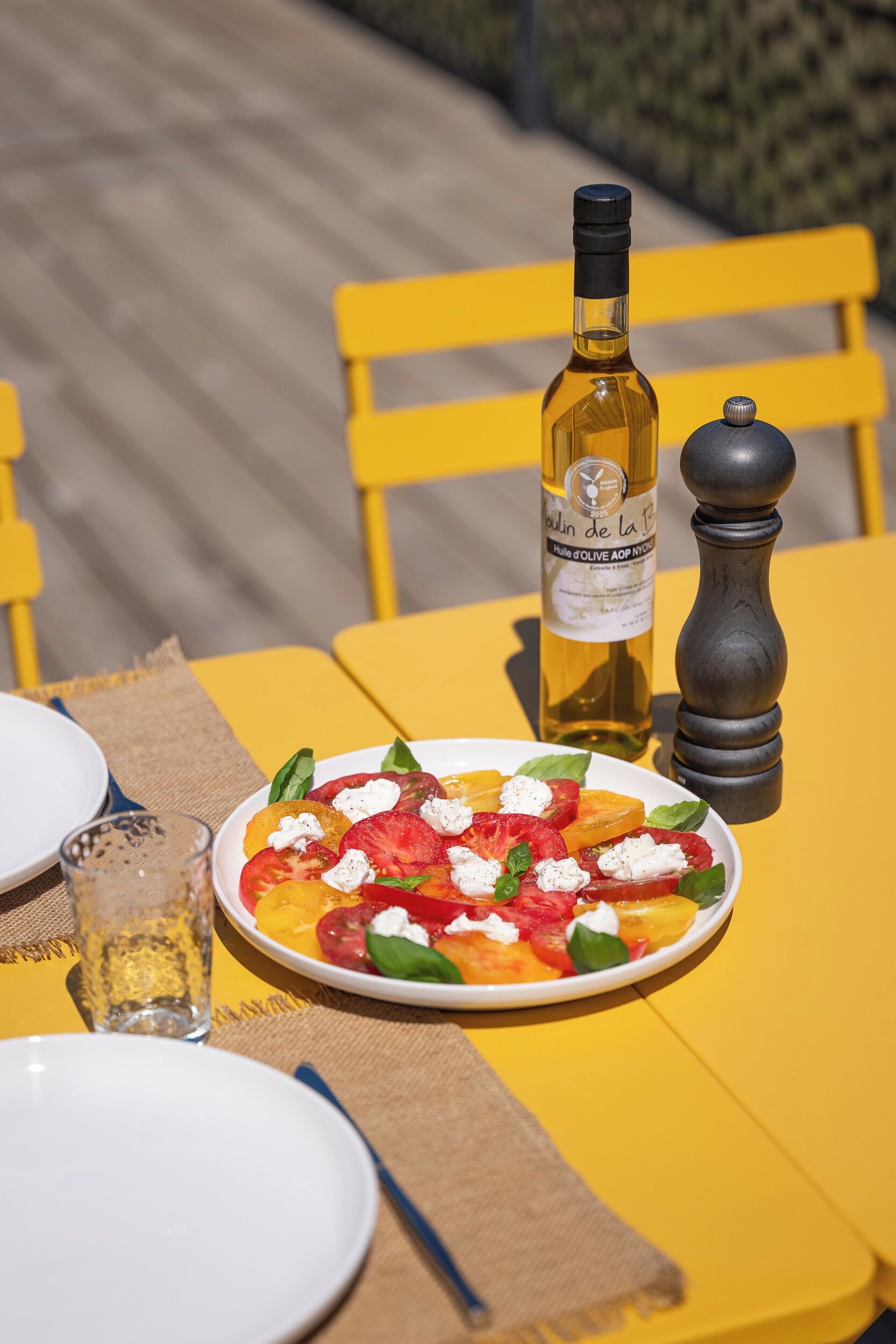 A dining table with a plate of food, a bottle of wine, and a salt shaker.
